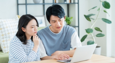パソコンの前で男性と女性が悩んでいる写真