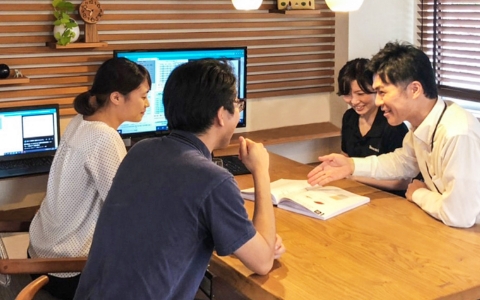女性と男性が女性と男性から説明を受けている写真