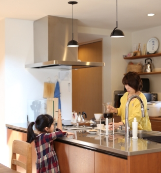 キッチンでコーヒーを淹れている母とそれを待っている娘